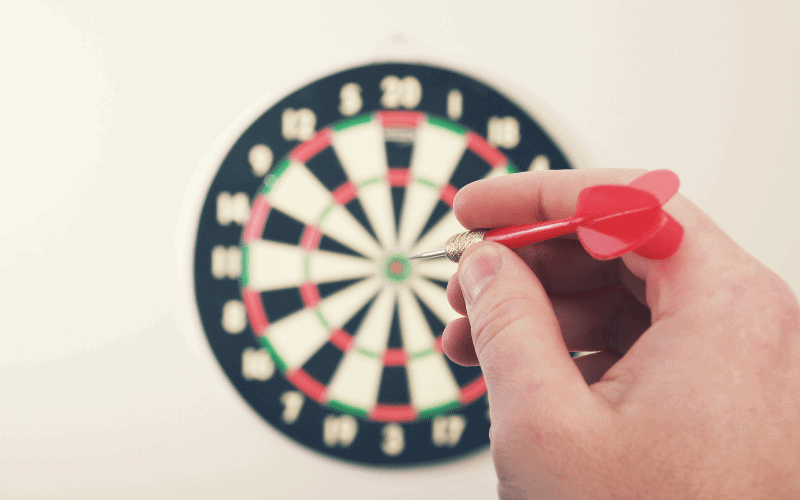 A dart player practices advanced training exercises, focusing on precision and accuracy. The player's concentration is evident as they aim for the bullseye on the dartboard